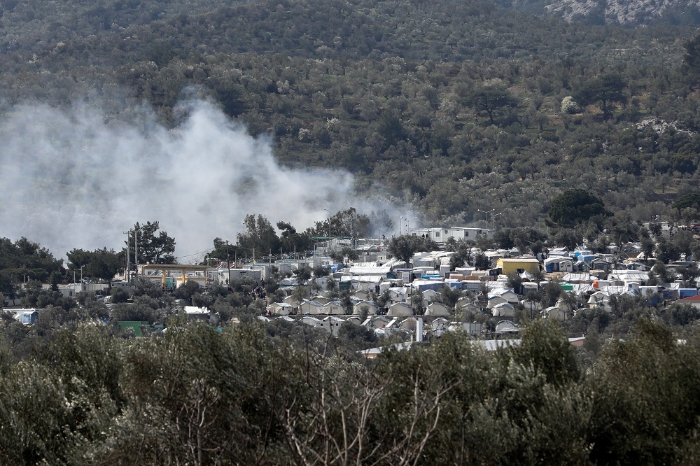 دخان يتصاعد من حريق بمخيم مكتظ بالمهاجرين في جزيرة ليسبوس اليونانية يوم الإثنين. تصوير: الياس ماركو - رويترز.